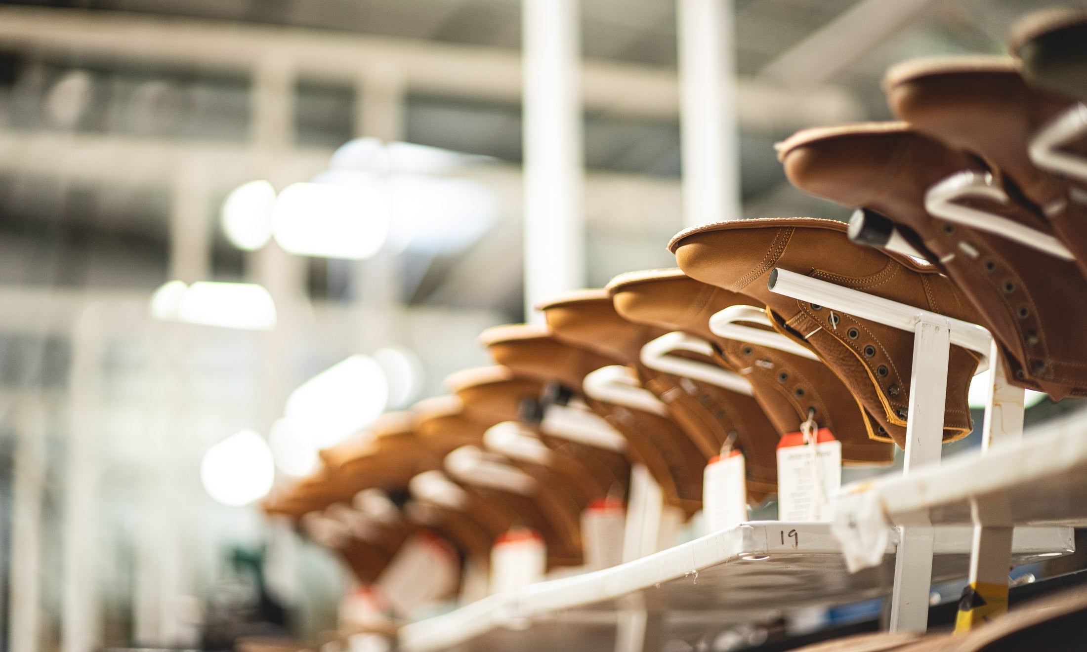 boot factory racks filled with unfinished tan leather boots