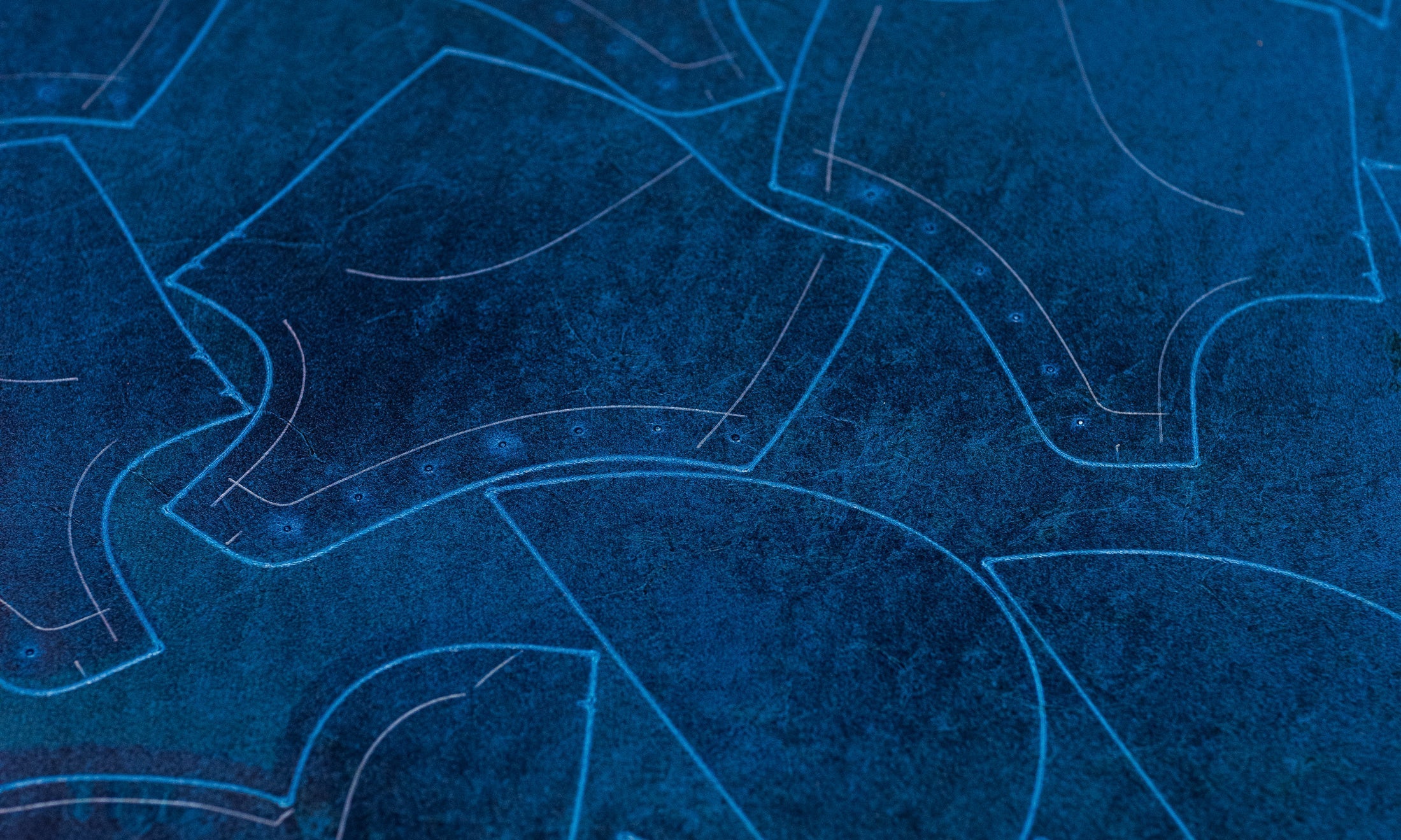 textured blue leather with light color outlines for pieces of boots on cutting machine