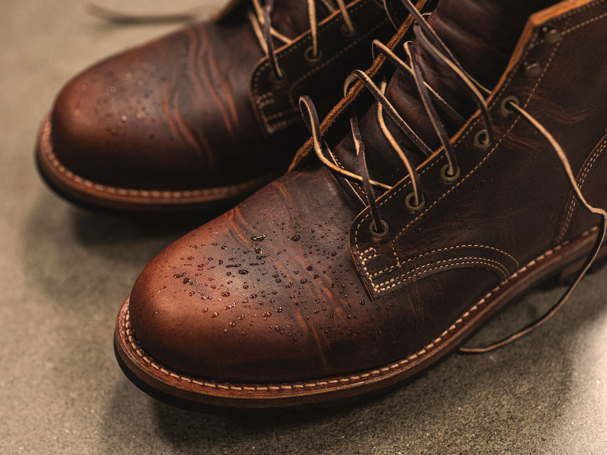 pair of tobacco snakebite plain toe boots on cement