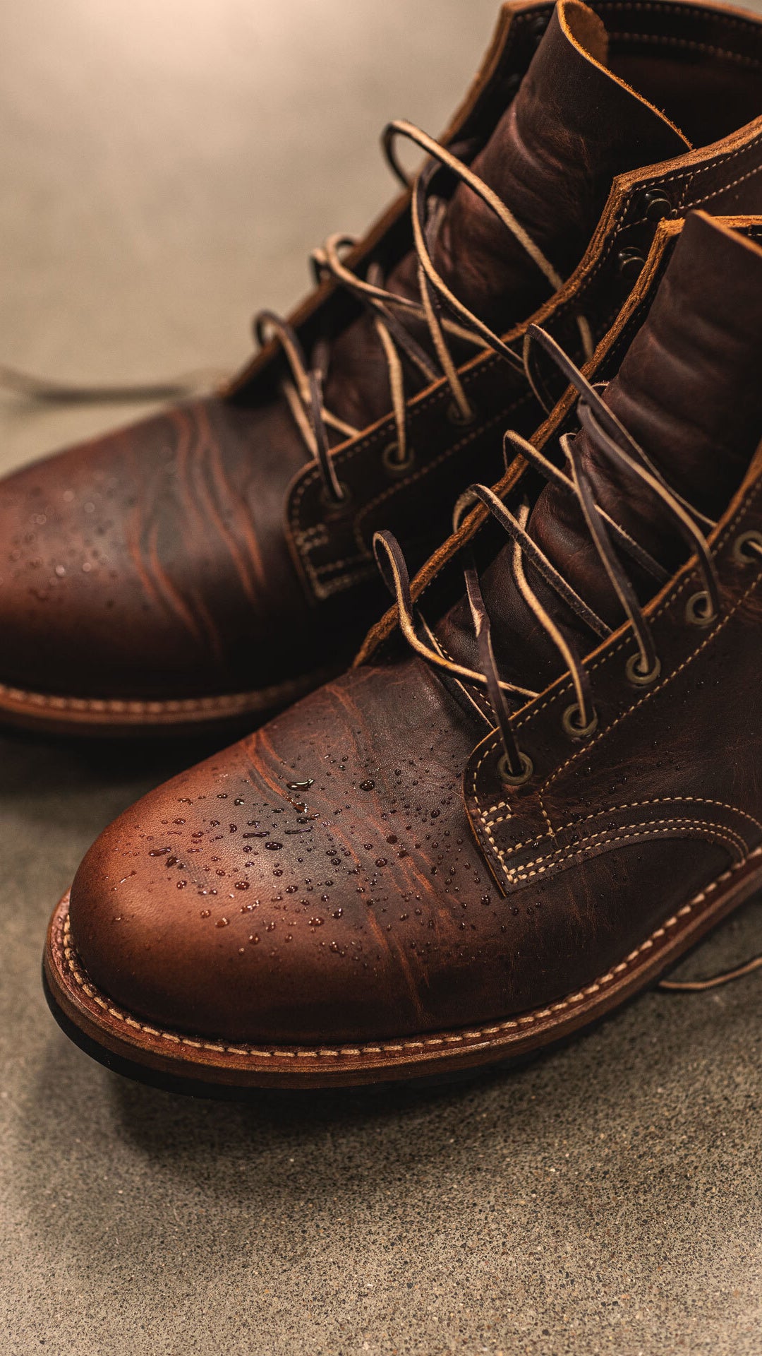 pair of tobacco snakebite plain toe boots on cement