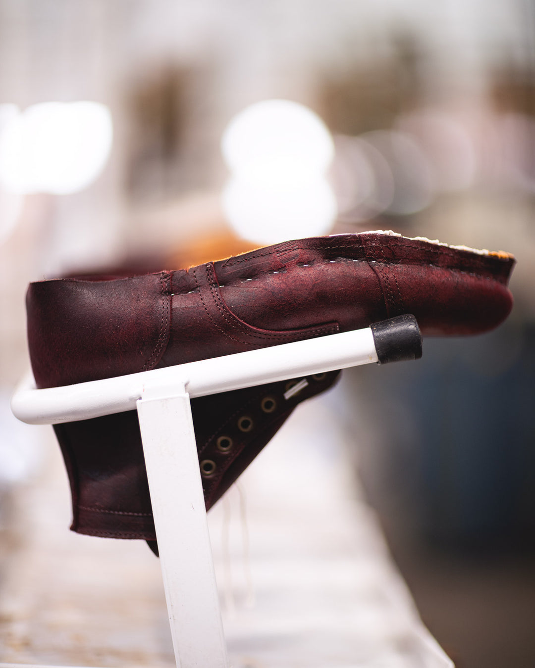 burgundy rambler boot in production upside down on factory rolling racks