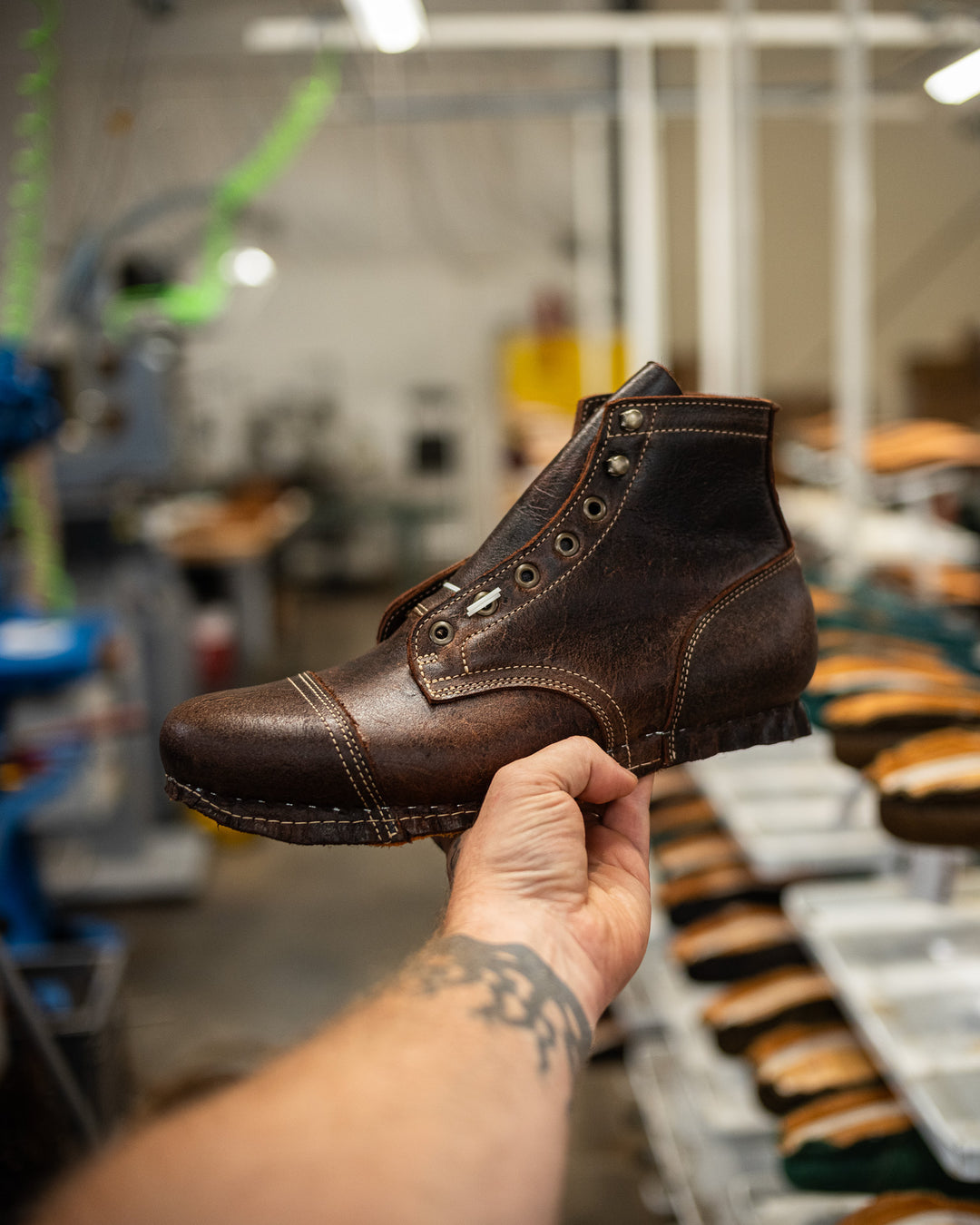 hand holding lasted snuff cap toe boot