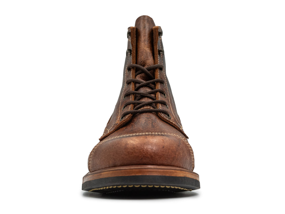 front view of brown textured leather boot on white background