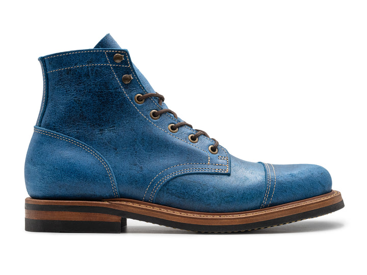 textured blue leather boot on white background