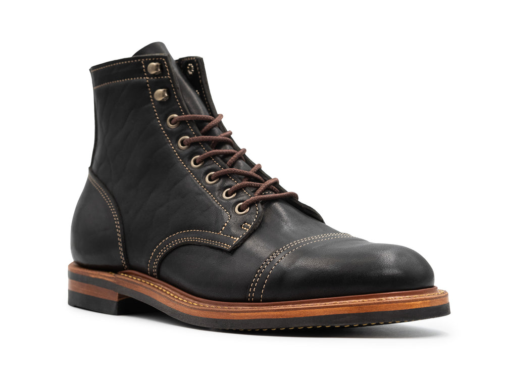 three-quarter view of black leather boot on white background