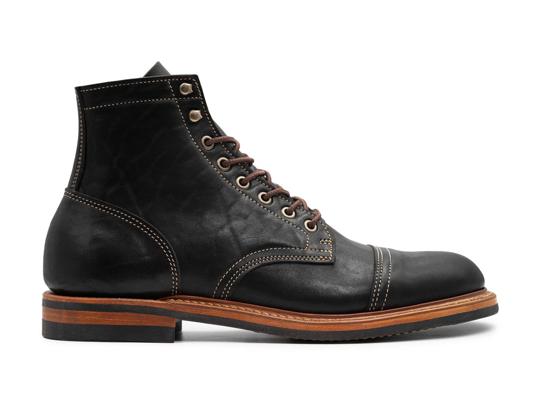 side view of black leather boot on white background
