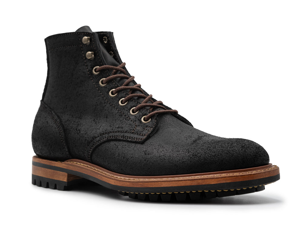 three-quarter view of black rough out boot on white background