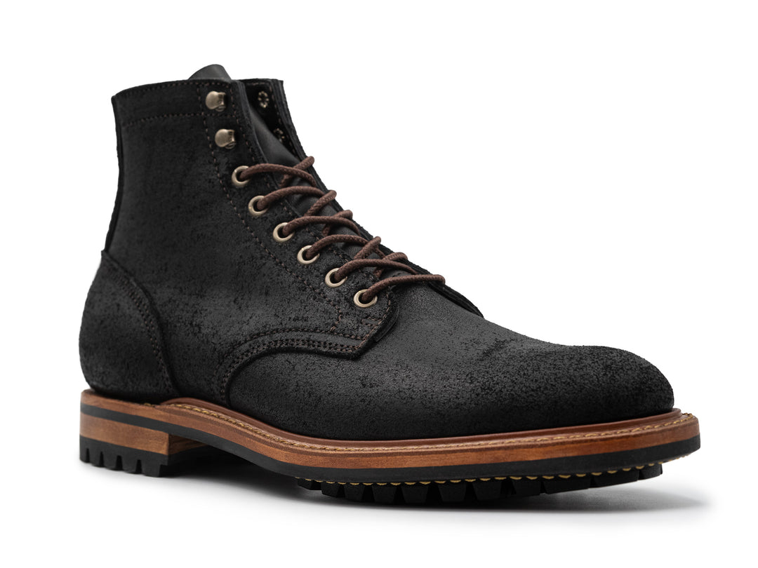three-quarter view of black rough out boot on white background
