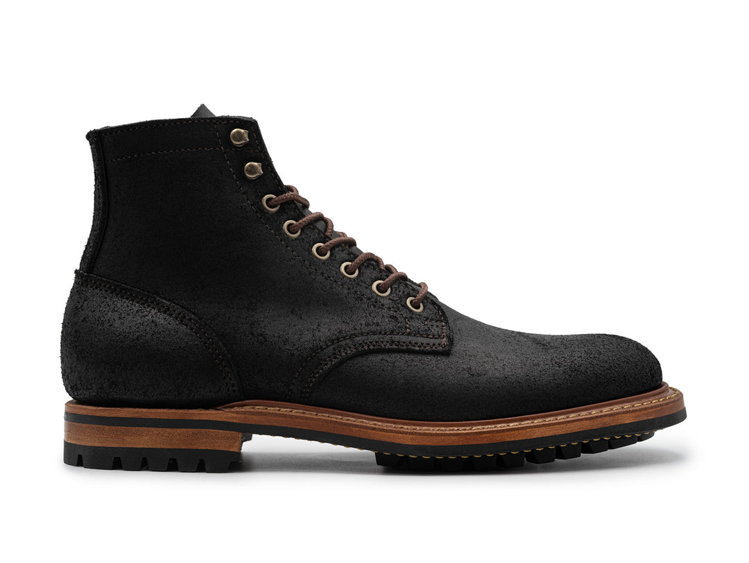 side view of black rough out boot on white background