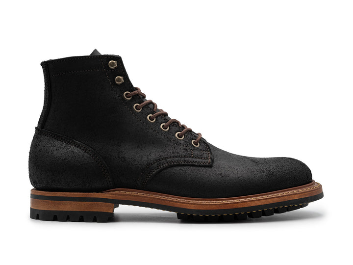 side view of black rough out boot on white background