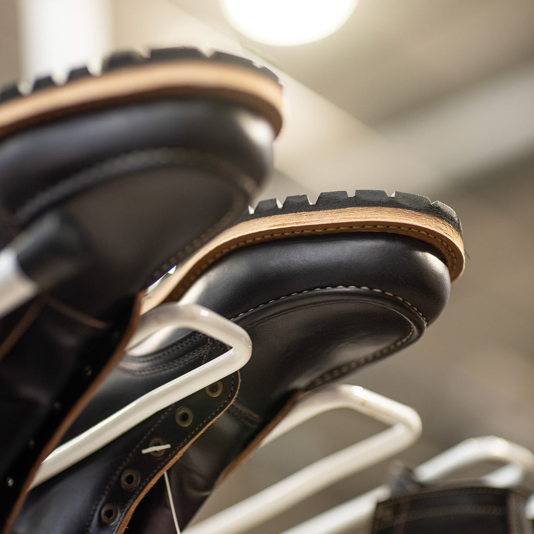 close up of black moc toes upside down on production rack