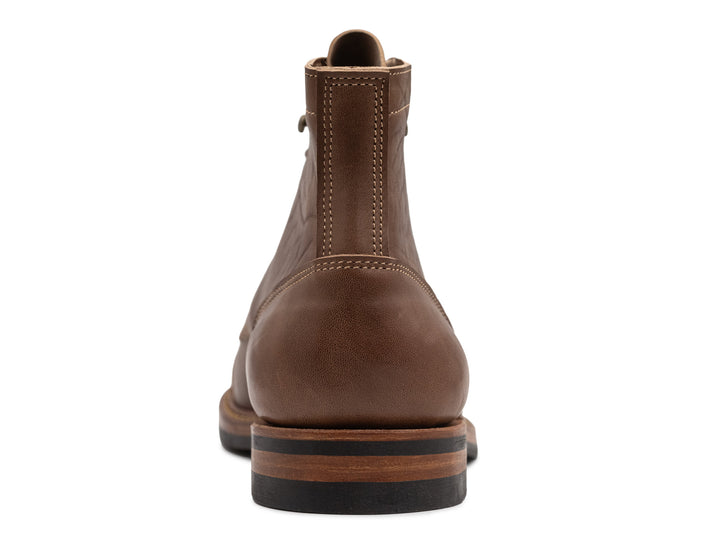 rear view of light brown leather boot on white background
