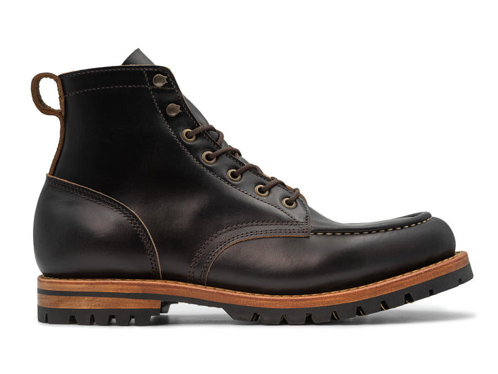 side view of black moc toe boot on white background