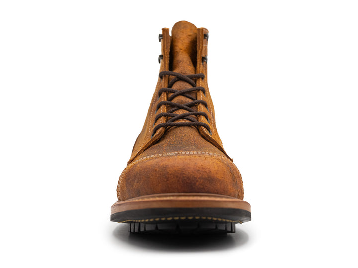 front view of single textured orange leather boot with black outsole on white background
