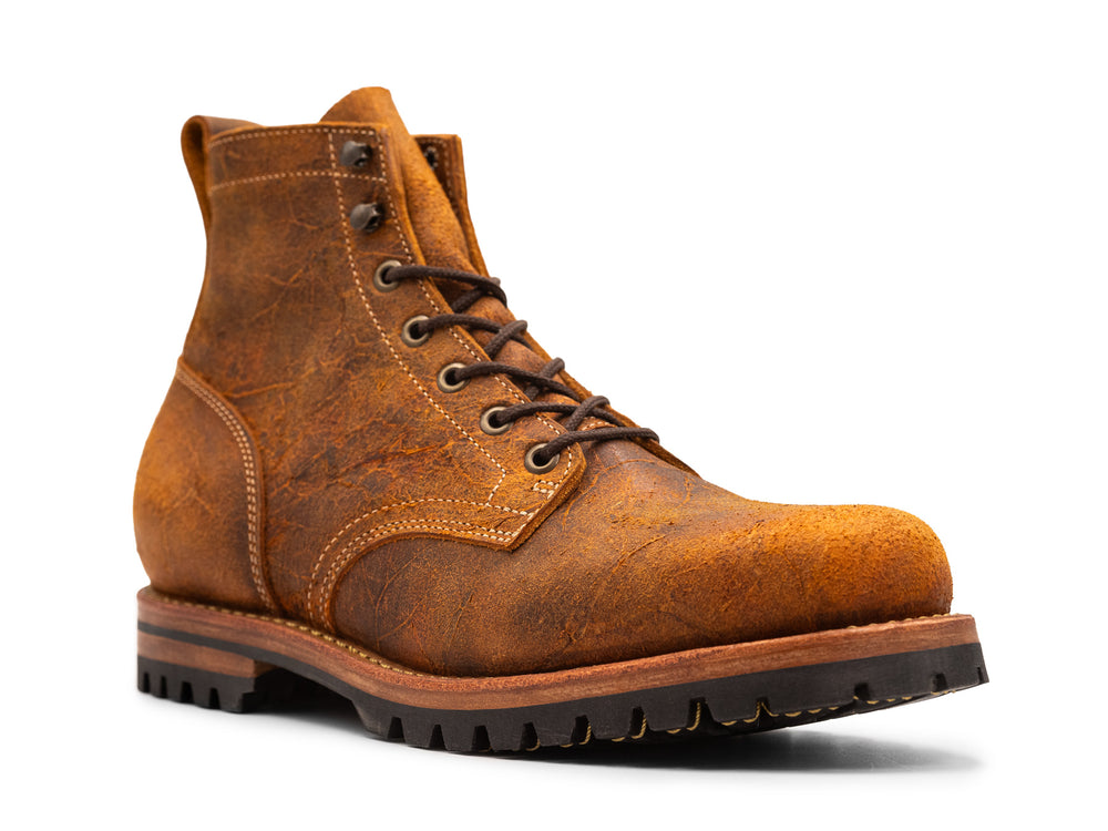 3QTR view of brown orange textured leather boot on white background