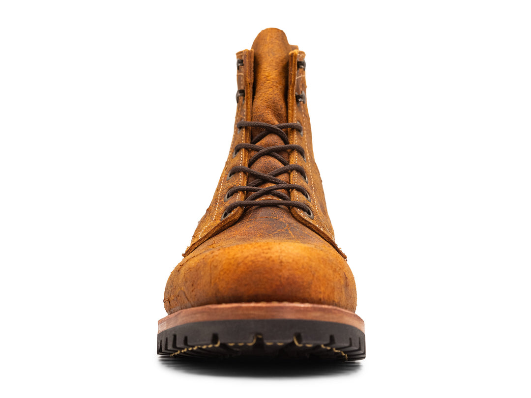 front view of brown orange textured leather boot on white background