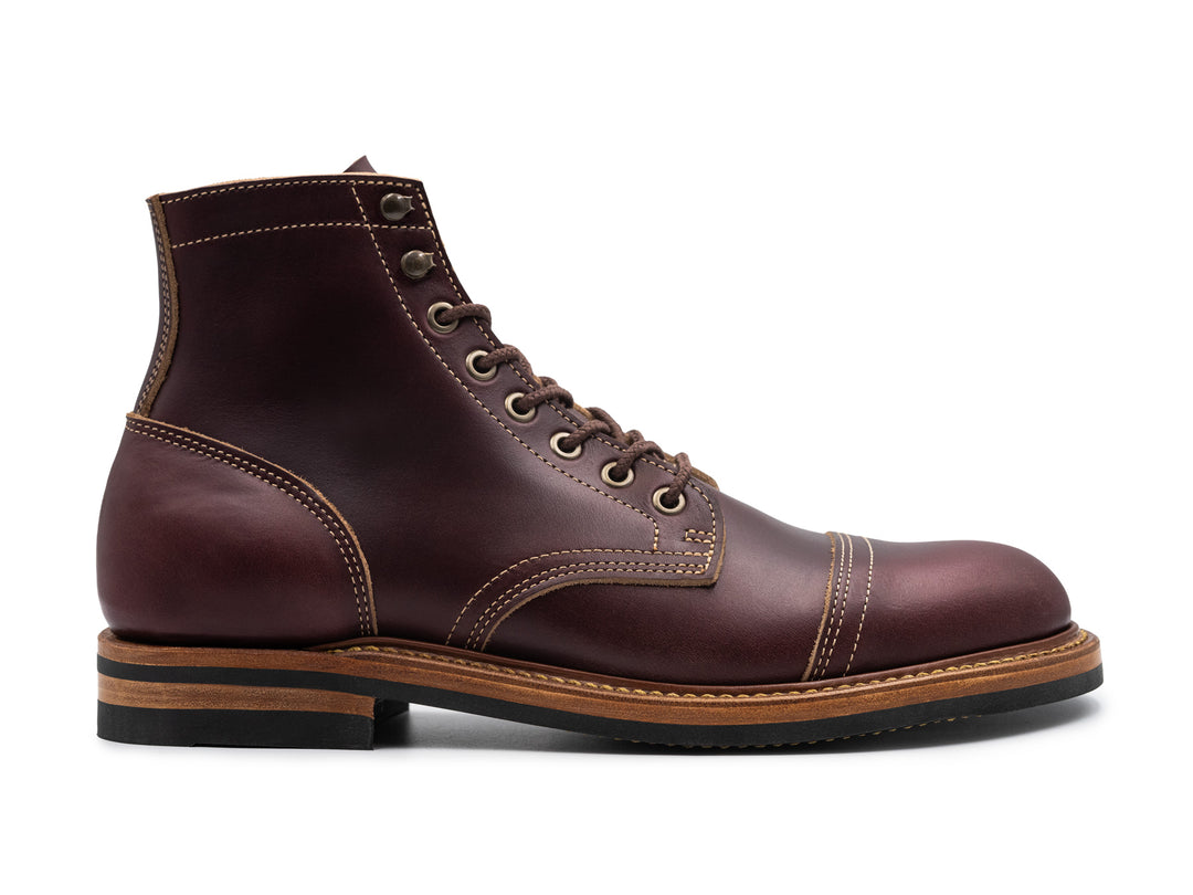 side view of dark burgundy leather boot on white background