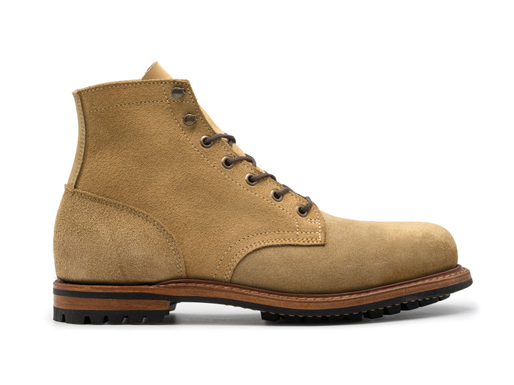 side view of tan leather boot on white background