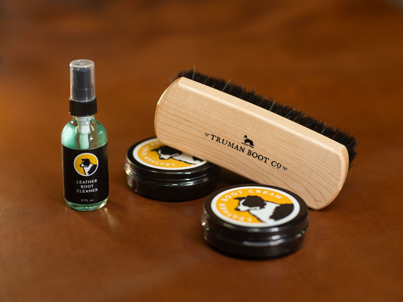 group of truman leather care items including leather cleaner boot protector and horsehair brush