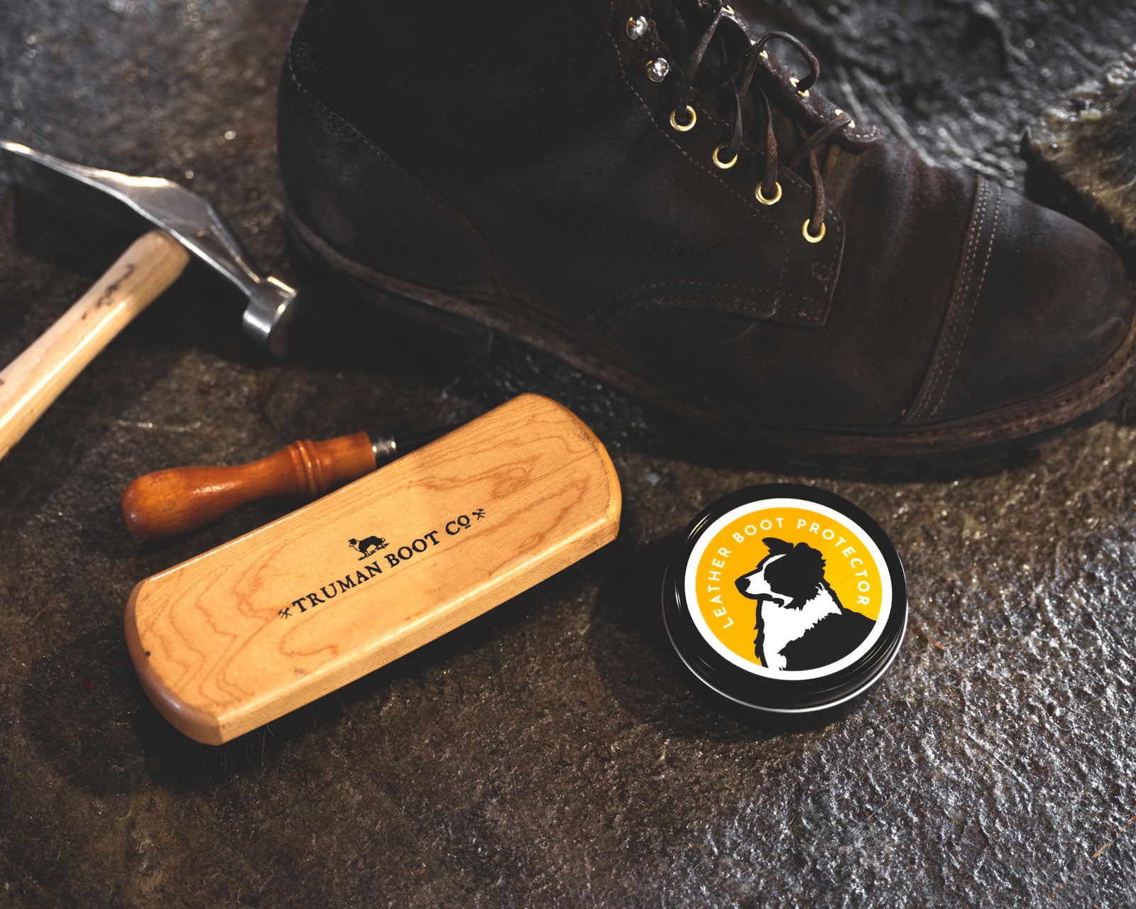 leather care items on bootmaking table with worn leather boot in black waxed flesh