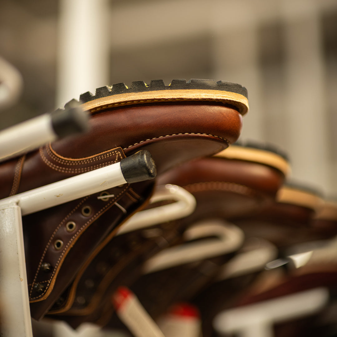 brown leather moc toe boot upside down in production rack in boot factory