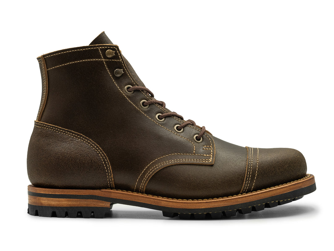 side view of olive waxed flesh leather boot on white background