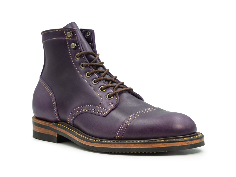 three-quarter view of vibrant purple leather boot on white background