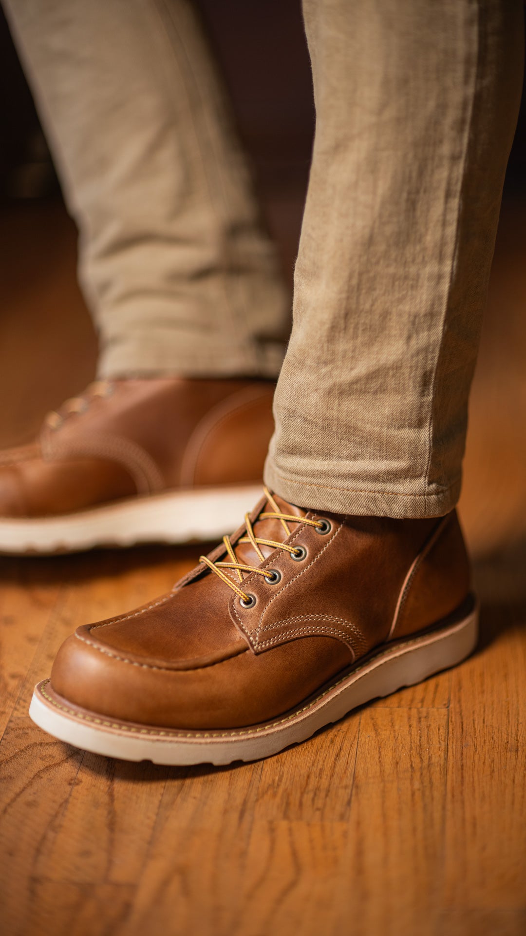 close up shot of man wearing khaki pants and caramel tan leather boots on wedge sole