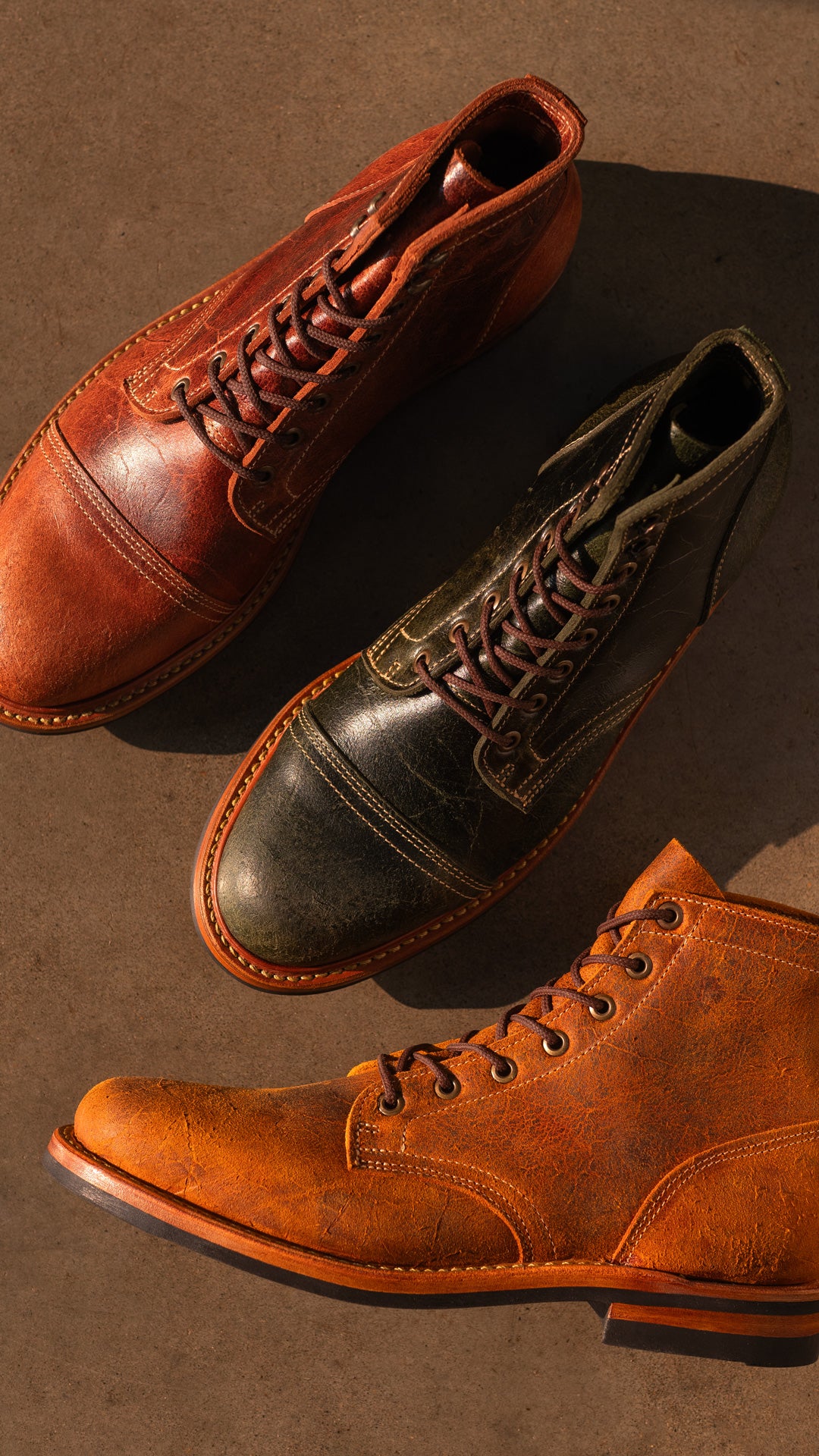 topdown view of textured colored leather boots on smooth concrete floor