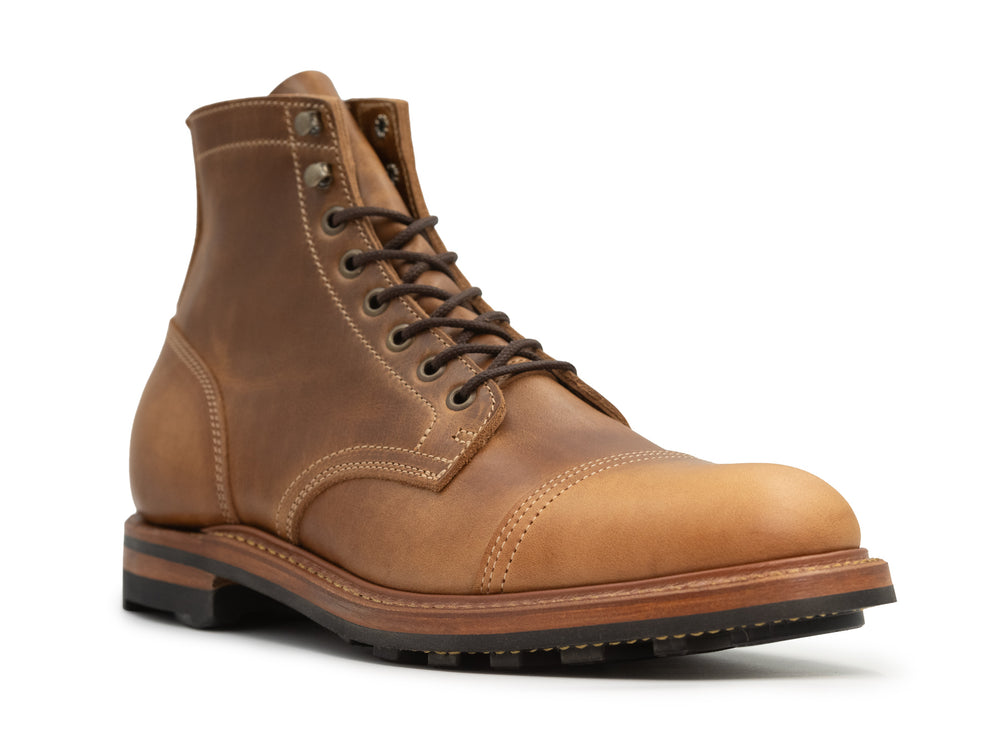 three-quarter view of tan caramel leather boot on white background
