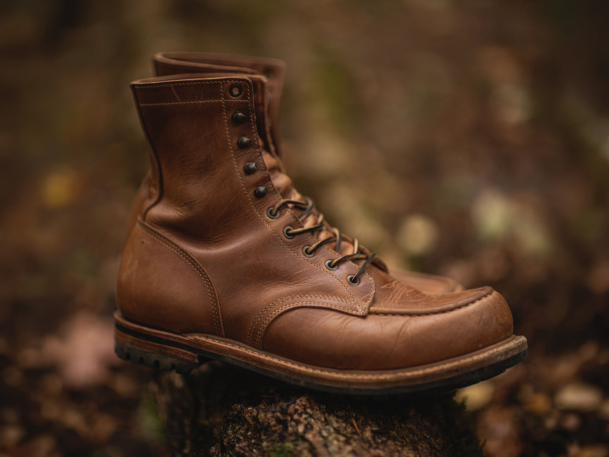 sesame double shot upland moc toe boot with out of focus foliage in background