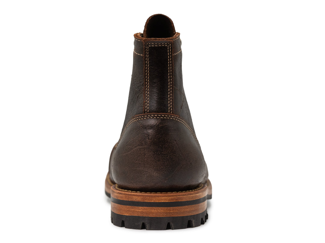 back view of brown textured leather boot on white background