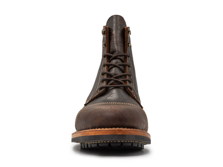 front view of brown textured leather boot on white background