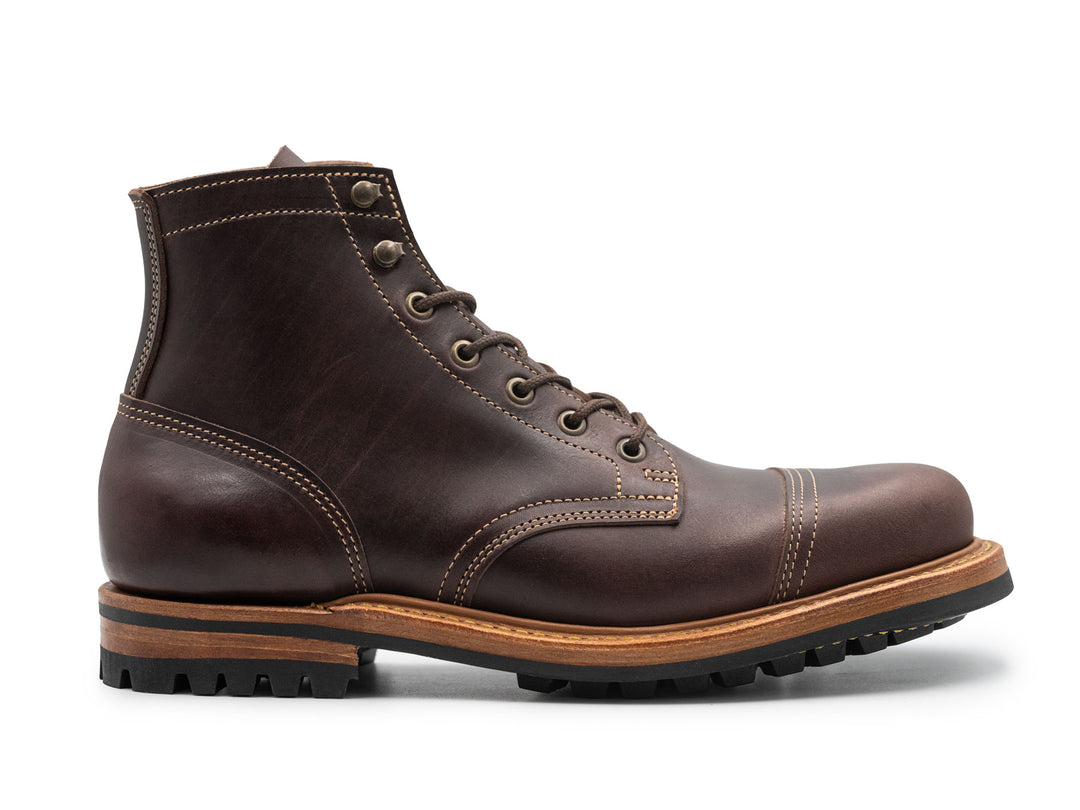 side view of brown leather cap toe boot on white background