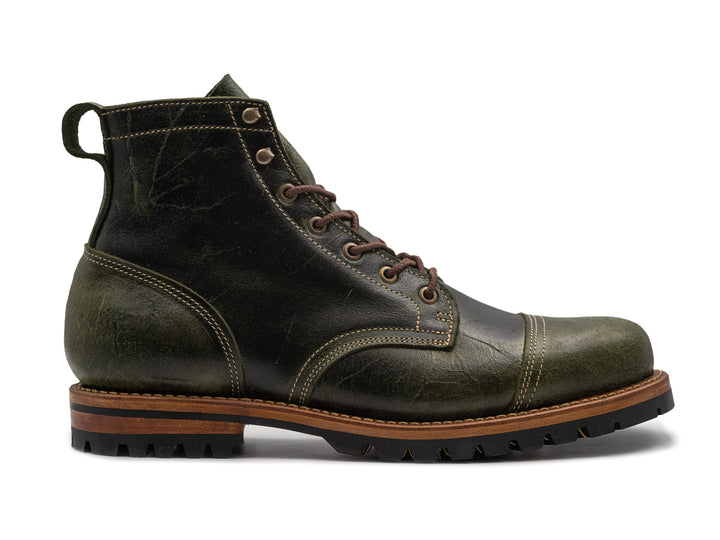 textured green leather boot on white background