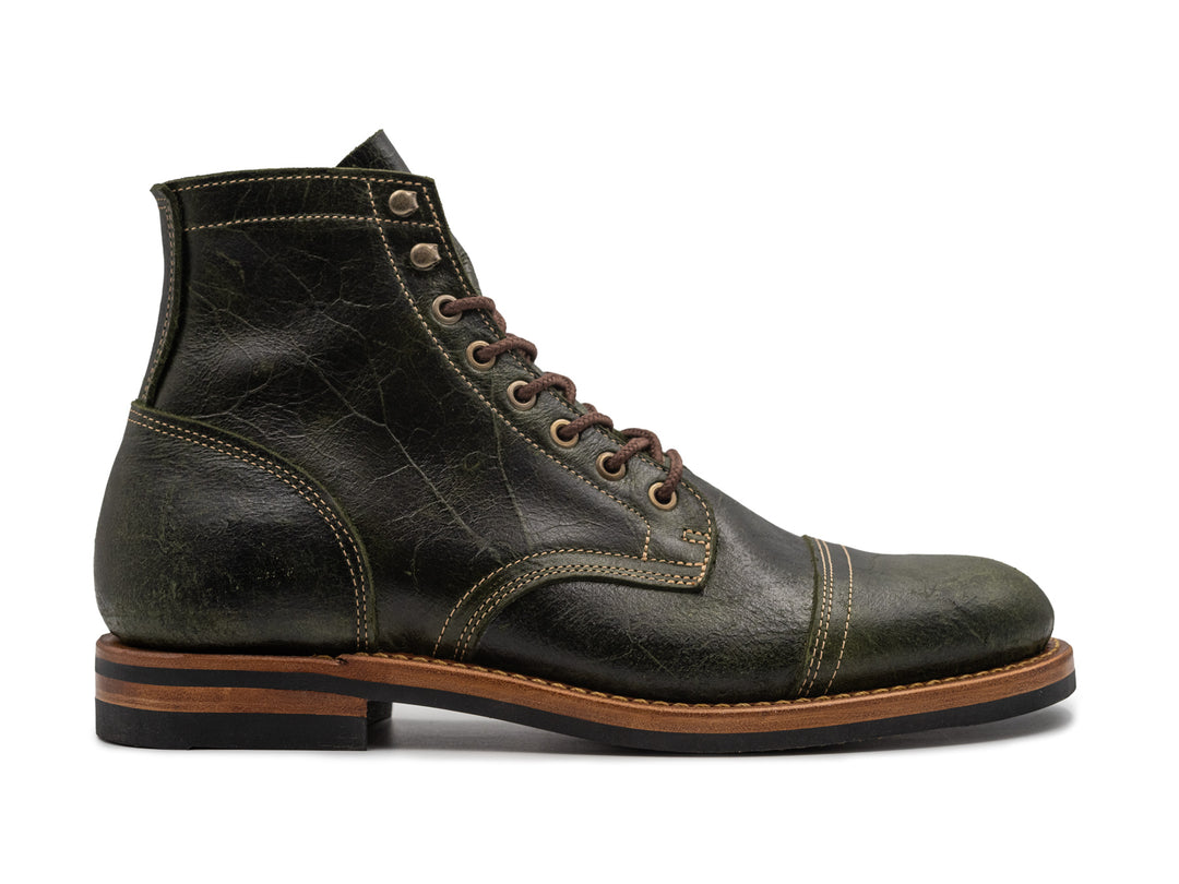 a dark green textured leather boot on white background