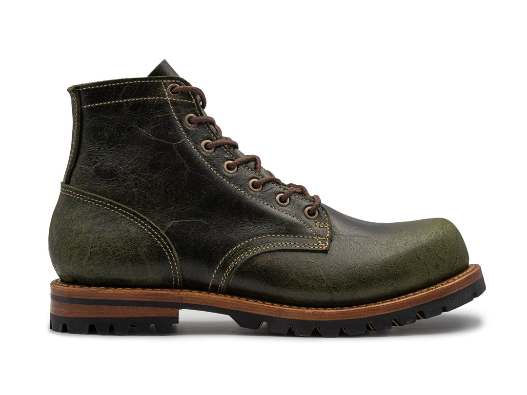 textured green leather boot on white background