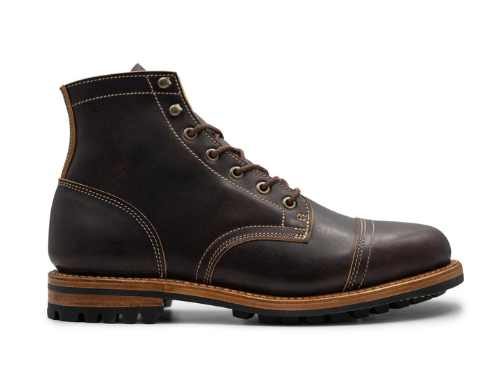 side view of black leather boot on white background