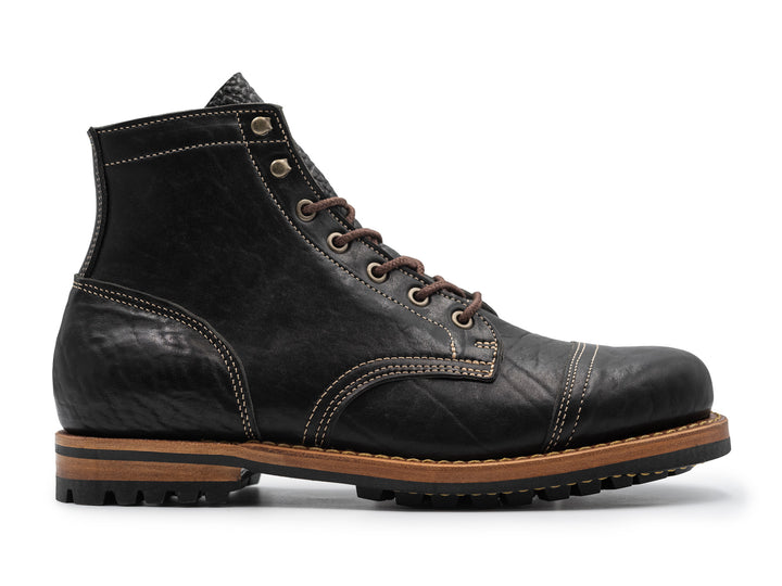 side view of black leather boot on white background