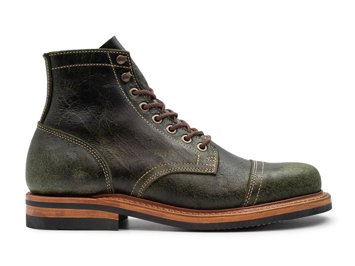 side view of green textured leather on white background