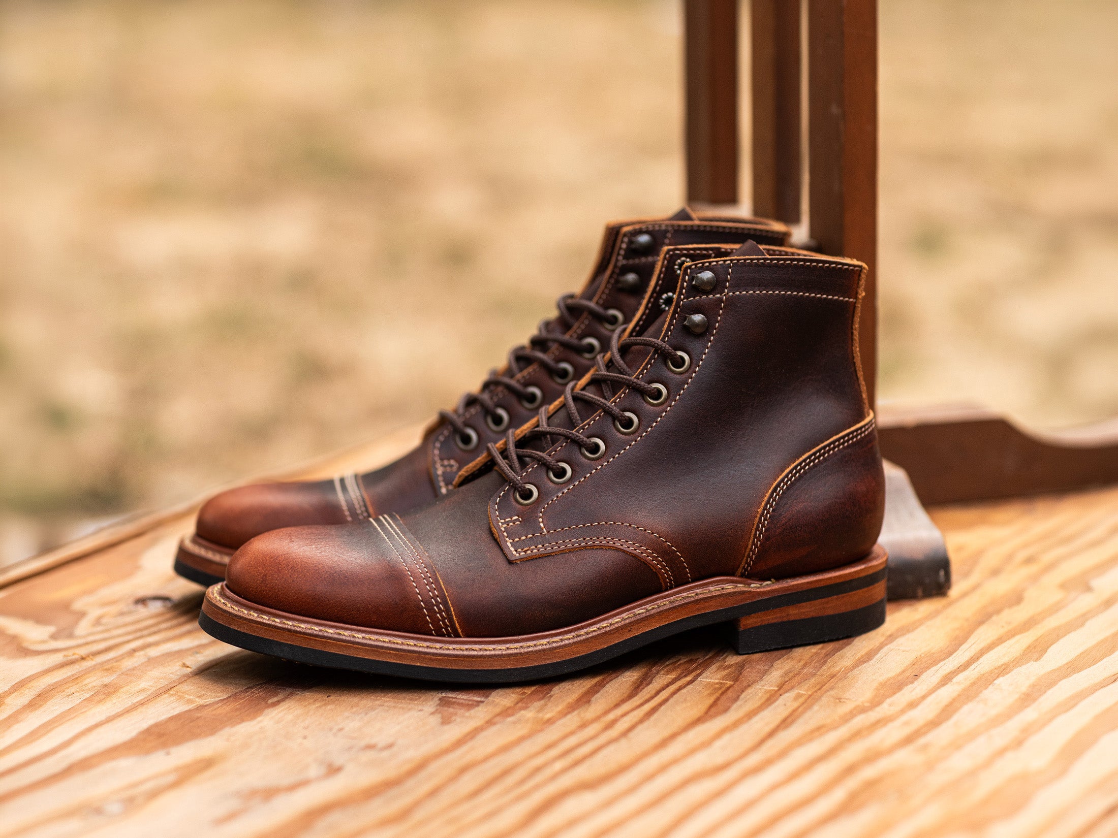 dark leather brown boots on out of focus tan background