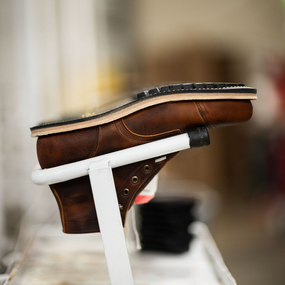 side view of tobacco snakebite boot in production after outsole stitching