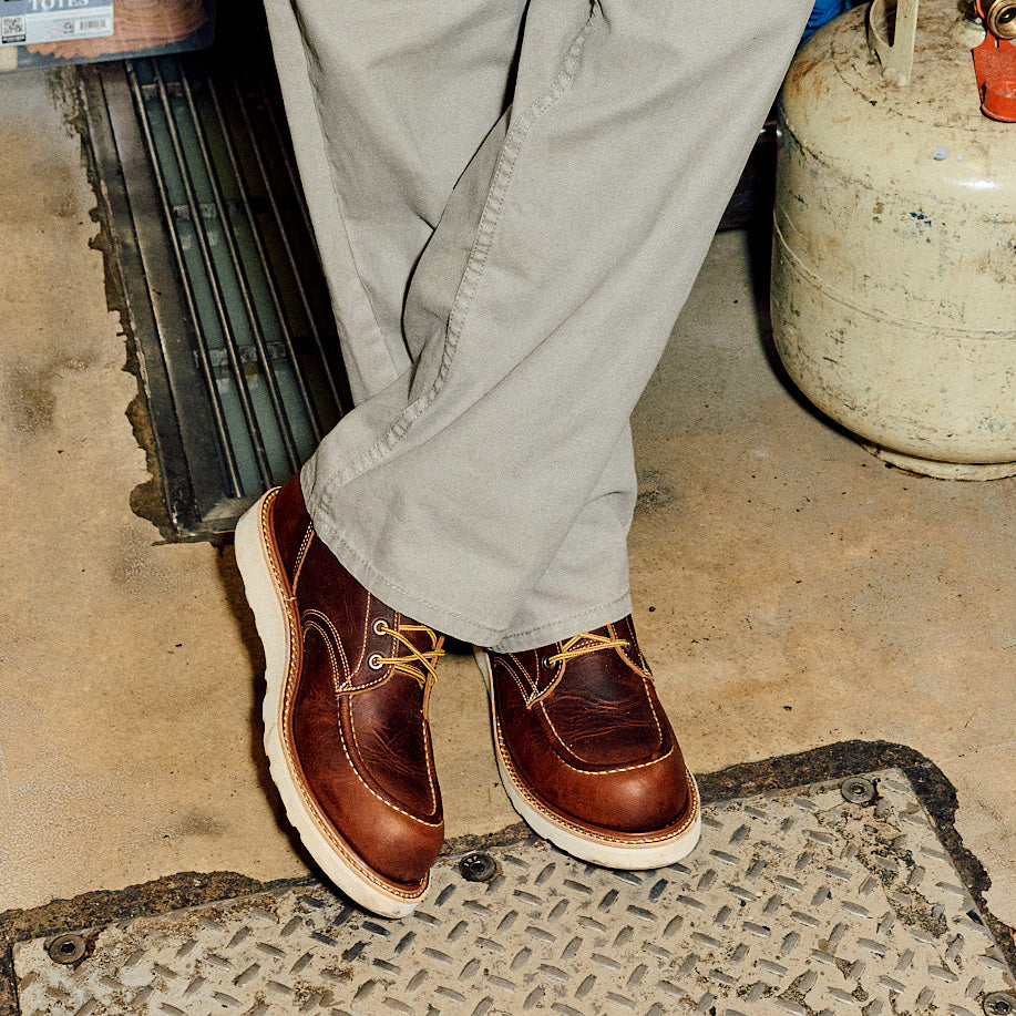 close up of brown leather moc toe boots in use on factory floor