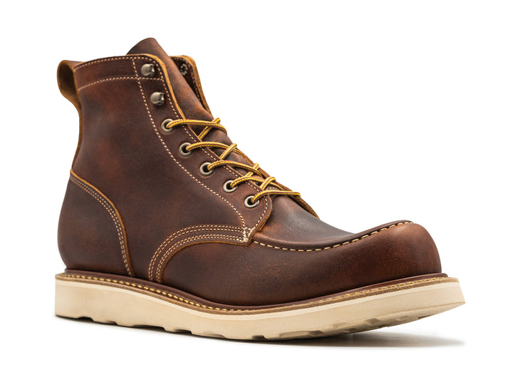 three-quarter view of rustic brown leather moc toe boot on white background