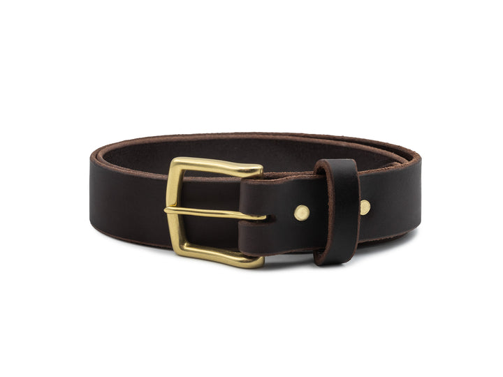 brown veg tan leather belt with brass buckle coiled on white background
